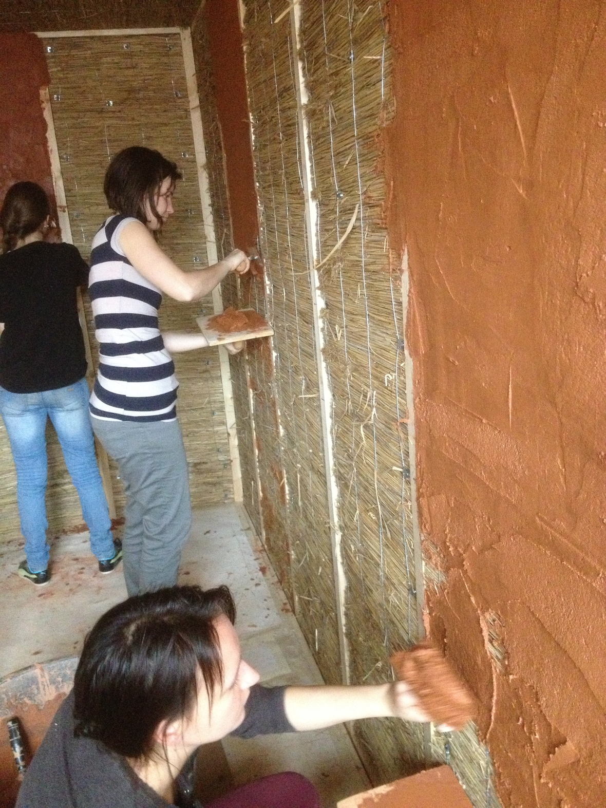 Hand plastering a straw bale house 2015