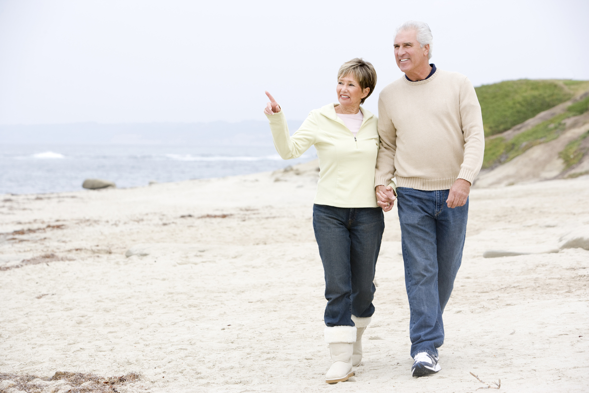 senior-couple-walking-along-beach Htphq0rs